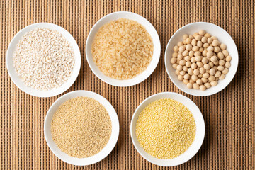 お皿に入れて並べた五穀（玄米、大豆、麦、粟、黍）