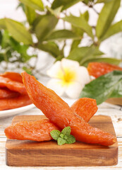 Sweet Dried Papaya Strips with Mint on Wooden Board - Healthy Tropical Fruit Snack