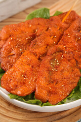 Grilled Meat Skewers with Sesame Seeds and Fresh Lettuce on Wooden Board