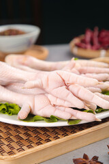 Fresh Raw Chicken Feet Paws with Claws on Plate Ready for Cooking with Pepper Marinade