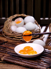 Fresh Free-Range Farm Eggs with Raw Yolks Displayed in Rustic Wicker Basket on Bamboo Mat