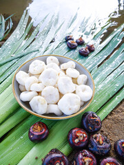 Fresh Water Chestnuts and Roasted Red Chestnuts on Banana Leaves - Tropical Food Ingredients Closeup