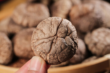 Hand Holding Dried Shiitake Mushroom with Natural Cap Texture Detail