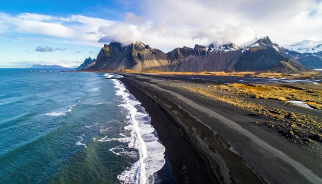 Dramatic black sand beach meets rugged mountains