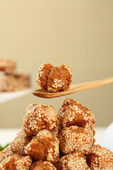 Traditional Guangxi Sesame Balls - Crispy Chinese Sweet Snacks with Sesame Seeds on Wooden Spoon