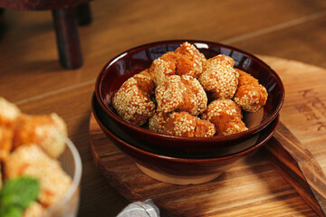 Crispy Sesame Balls Guangxi Chinese Deep Fried Dessert Specialty in Dark Bowl on Wooden Serving Tray