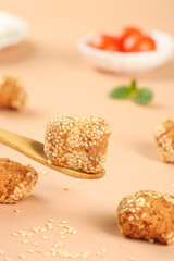Traditional Guangxi Sesame Seed Balls - Crispy Chinese Snacks on Wooden Spoon
