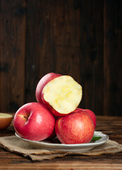 Fresh Red Fuji Apples Cut and Whole on Rustic Wood Background