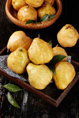 Fresh Chinese Pears in Wooden Bowl with Green Leaves on Dark Rustic Background