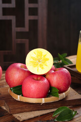 Fresh Red Apples in Bamboo Basket with Cut Apple Slice Showing Star Pattern on Rustic Wooden Table