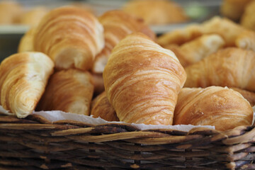 Warm golden croissants in a basket at a bakery