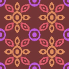 seamless geometric ornamental pattern featuring floral or abstract shapes in shades of pink, orange, and purple against a reddish-brown background. Ikat textiles. 