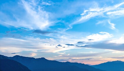 Obraz premium A vast, shimmering lake stretches out under a clear blue sky, surrounded by lush green hills and dotted with small boats gliding across the surface.