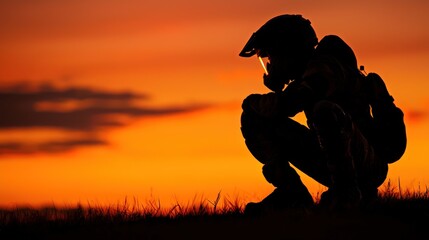 A silhouette of a person in a helmet against a vibrant orange and red sunset sky.