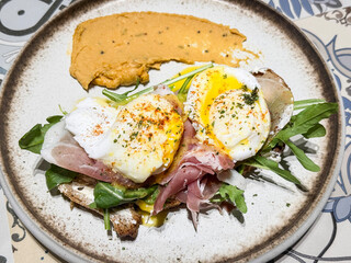 Poached Perfection: Gourmet Breakfast with Rustic Bread, Greens, and Paprika Elegance