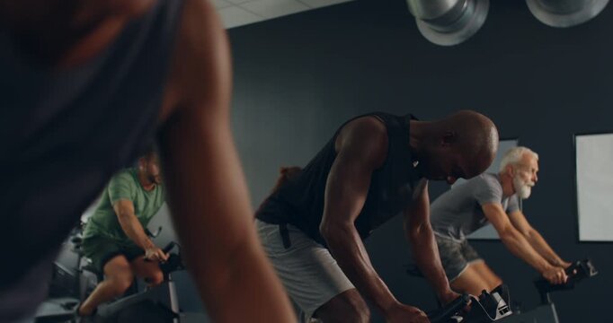 Fit young man in sportswear
exercising in a cycling class with a
diverse group of people in a gym