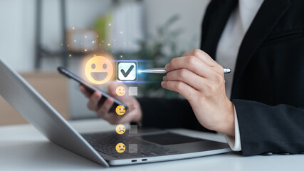 Businessman using digital device to select happy face emoji in online customer feedback and satisfaction survey concept for service rating and user experience.