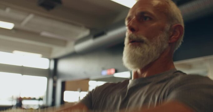 Fit mature man in sportswear
exercising with a kettlebell during a
weight training session in a gym