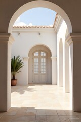 Obraz premium Sunlit white corridor with arched doorway and potted palm.