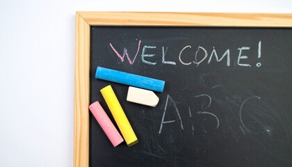 A school blackboard with a welcome message and the letters ABC written in colorful chalk.