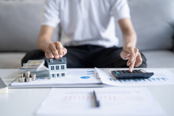 Saving money. Man calculate finances home pay bills taxes savings economy financial at home and saving money stacking coins with calculator