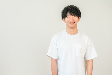 オーバーサイズtシャツ姿の笑顔のアジア人男性  © buritora