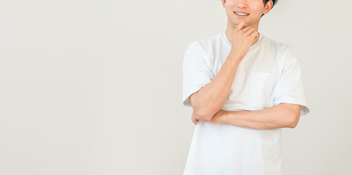 頬杖をつく笑顔の若いアジア人男性（想像,思い出,思い浮かぶ,アイデア,将来,夢,妄想）
