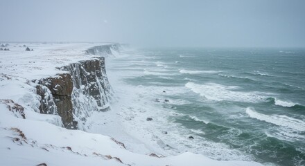 Snowy cliffs stand over a turbulent ocean during a winter storm