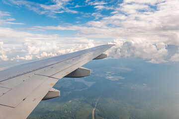 Obraz premium View from the airplane window at a beautiful cloudy sky and the airplane wing