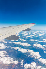 Obraz premium View from the airplane window at a beautiful cloudy sky and the airplane wing