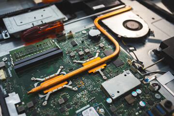 Close-up image of an all-in-one computer interior showing the motherboard, heat pipe cooling system, RAM slot, processor, and electronic components. Inside View of All-in-One Computer Motherboard