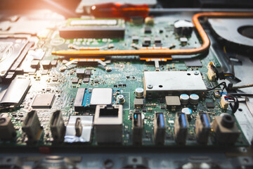 Close-up image of an all-in-one computer interior showing the motherboard, heat pipe cooling system, RAM slot, processor, and electronic components. Inside View of All-in-One Computer Motherboard