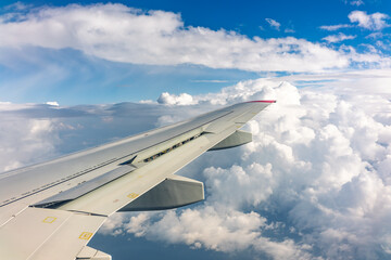 View from the airplane window at a beautiful cloudy sky and the airplane wing