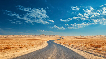 Long winding asphalt road stretching through a vast arid desert landscape under a dramatic blue sky