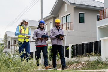 Construction engineers walking through residential development site to inspect and coordinate building progress, discussing work progress while walking through residential infrastructure project