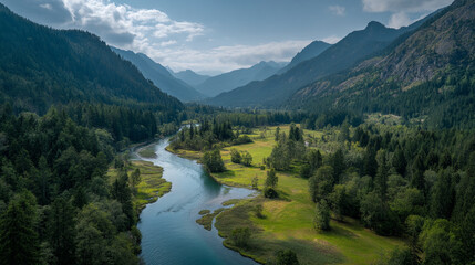 Obraz premium Aerial view of winding river through valley with mountains and forest under cloudy sky