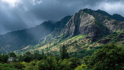 Sunbeams pierce dark clouds illuminating a verdant mountain range, revealing lush valley with scattered houses