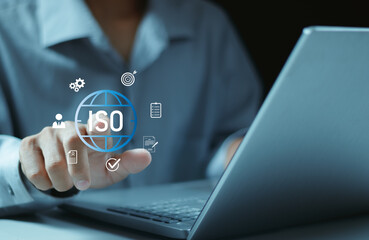 ISO Certification concept. Quality assurance, compliance, global standards, and International organization. Person using laptop with ISO icon on virtual screen.
