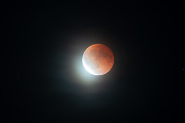 Munich, Germany - September 7th 2025: Total lunar eclipse (blood moon) with red-tinged lunar surface and bright crescent emerging against a dark night sky above Munich.
