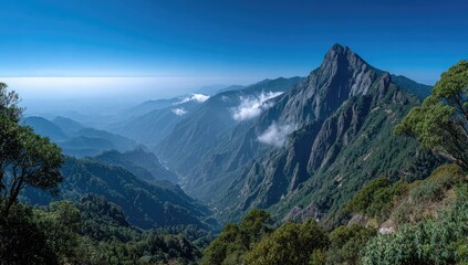 Panoramic view of a majestic mountain range on a clear day, showcasing deep valleys shrouded in morning mist, and lush green vegetation on the slopes