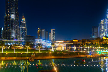 Evening view of the Dubai Fountain, Dubai Mall and skyline, including the base of the Burj Khalifa, in downtown Dubai, United Arab Emirates.