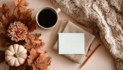 Flatlay autumn scene coffee, blank card, cozy knit, pumpkins, dried leaves on blush background