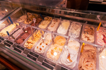 Artisanal gelato in a refrigerated shop case, summer dessert indulgence.