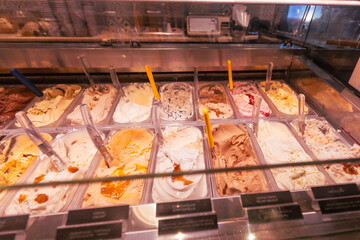 Artisanal gelato in a refrigerated shop case, summer dessert indulgence.