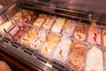 Artisanal gelato in a refrigerated shop case, summer dessert indulgence.