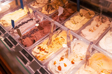 Artisanal gelato in a refrigerated shop case, summer dessert indulgence.