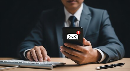 Businessman checking email on smartphone while working at the office