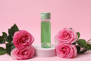 pink roses, cosmetic jars on a pink background
