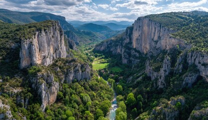 Obraz premium High-angle view of a verdant valley carved by a river, surrounded by sheer cliffs