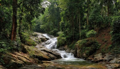 Obraz premium Lush waterfall cascading down rocky streambed in dense tropical forest